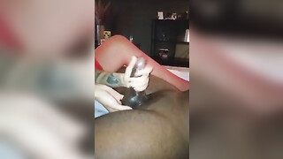 Hot blonde in red lingerie performing a handjob on black penis until he cums